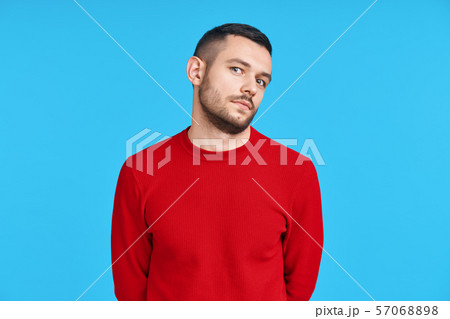 Shy confused man portrait on blue background 57068898