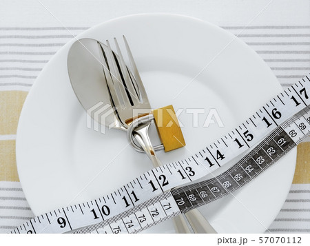 Fork with padlock and measuring tape on a plate 57070112