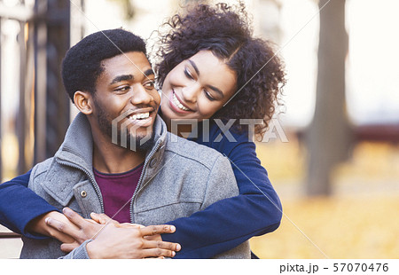 Cute black girl flirting with boyfriend, hugging from behind Cute black girl flirting with boyfriend, hugging from behind 57070476