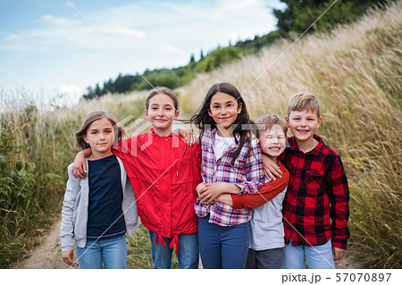 Group of school children standing on field trip in nature, looking at camera. Group of school children standing on field trip in nature, looking at camera. 57070897