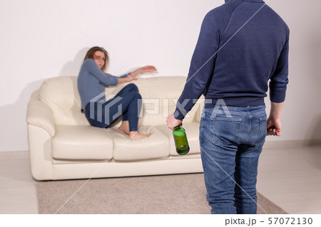 alcoholic, domestic violence and abuse concept - man gets drunk at home and takes his anger at his 57072130