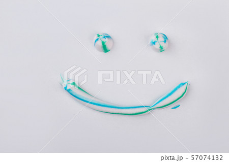 Toothpaste in a shape of face with smile. Toothpaste in a shape of face with smile. 57074132