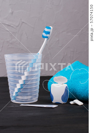 Glass with toothbrush, dental floss and towel. Glass with toothbrush, dental floss and towel. 57074150