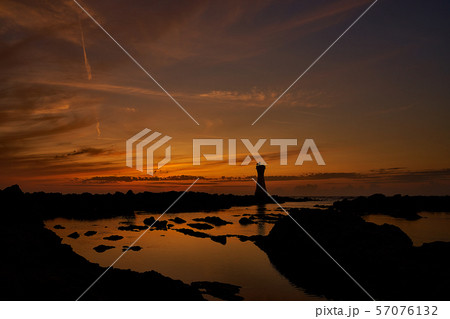 佐渡　長手岬の灯台と夕日（海面有） 57076132