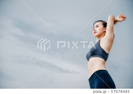 An beautiful Asian woman running and drinking some An beautiful Asian woman running and drinking some 57078485