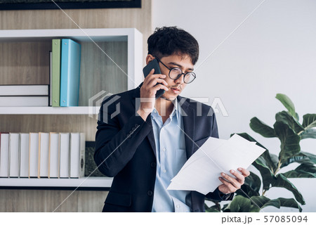 Young Asian businessman wear suit talking on 57085094