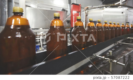 Plastic bottles for beer or carbonated beverage moving on conveyor. Shallow DOF. Selective focus. Plastic bottles for beer or carbonated beverage moving on conveyor. Shallow DOF. Selective focus. 57087222