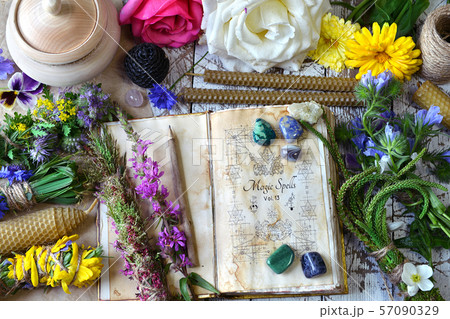 Witch spell book, calendula, rose flowers, reiki crystals and candles on wooden table Witch spell book, calendula, rose flowers, reiki crystals and candles on wooden table 57090329
