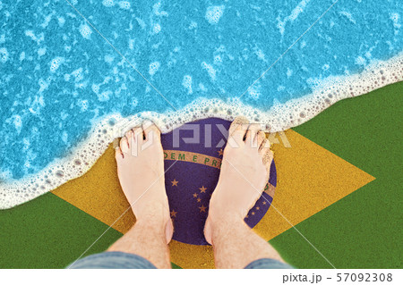 Feet on the sunny sandy beach with flag Brazil. 57092308