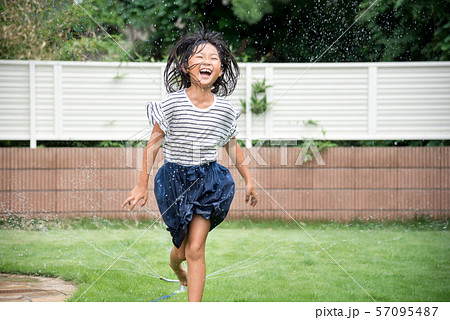 庭で水遊びをする女の子の写真素材