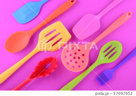 bright multi colored kitchen utensils on purple background 57097952