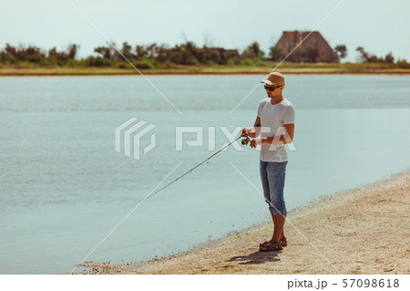 Young man fishing at sea Young man fishing at sea 57098618