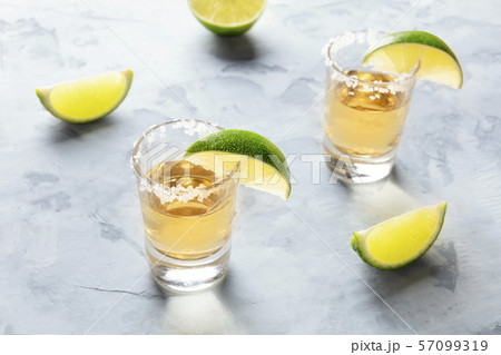 Golden tequila shots with lime slices and salt Golden tequila shots with lime slices and salt 57099319