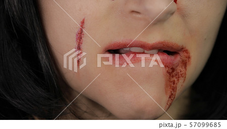 Vampire Halloween woman portrait. Vampire girl with dripping blood near her lips 57099685