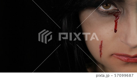 Vampire Halloween woman portrait. Vampire girl with dripping blood near eyes 57099687