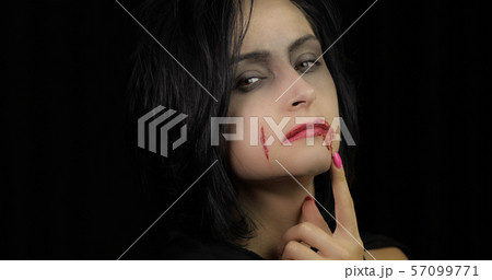 Vampire Halloween makeup. Woman portrait with blood on her face. 57099771