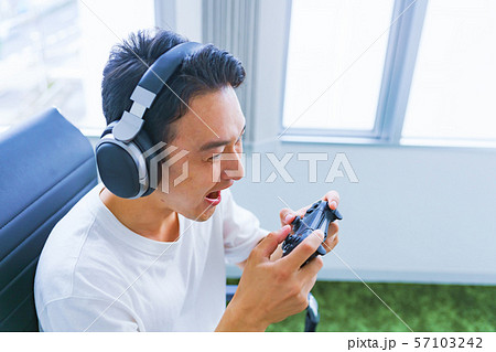 eスポーツのイメージ:コントローラーを片手に若者がゲームのプレイでエキサイティングしているシーン eスポーツのイメージ:コントローラーを片手に若者がゲームのプレイでエキサイティングしているシーン 57103242