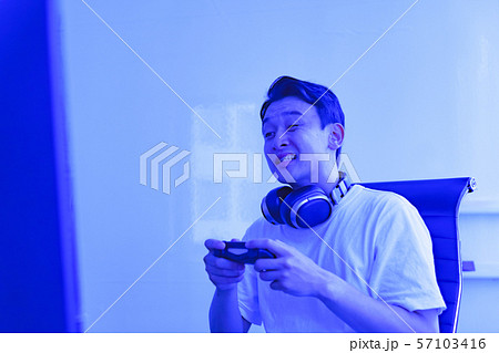 eスポーツのイメージ:コントローラーを片手に若者がゲームのプレイでエキサイティングしているシーン eスポーツのイメージ:コントローラーを片手に若者がゲームのプレイでエキサイティングしているシーン 57103416