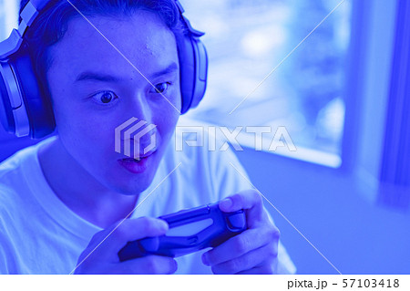 eスポーツのイメージ：コントローラーを片手に若者がゲームのプレイでエキサイティングしているシーン 57103418