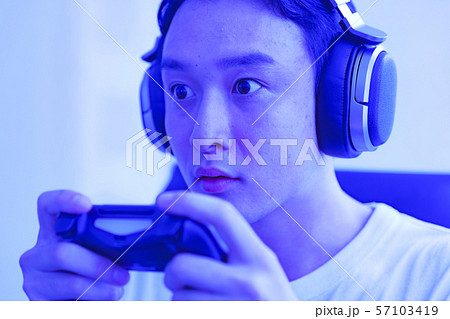 eスポーツのイメージ：コントローラーを片手に若者がゲームのプレイでエキサイティングしているシーン 57103419