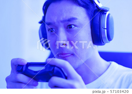 eスポーツのイメージ:コントローラーを片手に若者がゲームのプレイでエキサイティングしているシーン eスポーツのイメージ:コントローラーを片手に若者がゲームのプレイでエキサイティングしているシーン 57103420
