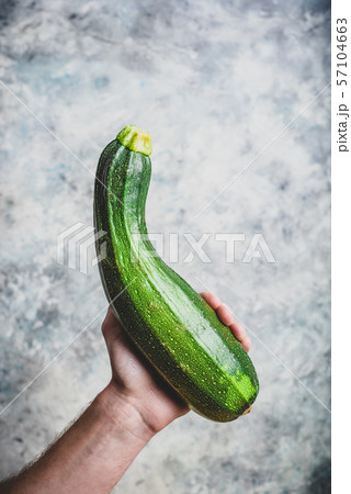 Hand holding zucchini 57104663