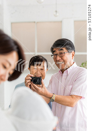 デジカメで孫の写真を撮るシニア夫妻 57105274