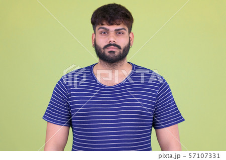 Young overweight bearded Indian man looking at camera Young overweight bearded Indian man looking at camera 57107331