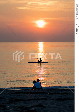 カップル 海 夕日の写真素材