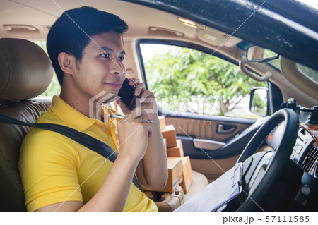 Young Asian Delivery man calling phone to customer 57111585