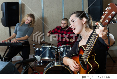 excited girl rock singer with guitar during rehearsal excited girl rock singer with guitar during rehearsal 57116611