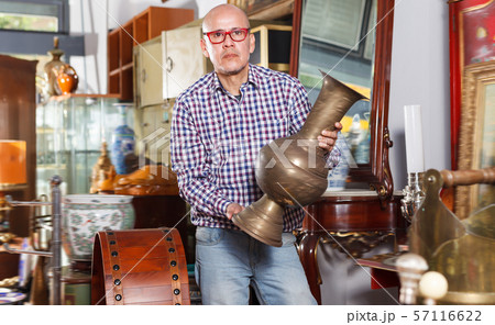 Interested mature man measuring vintage amphora 57116622