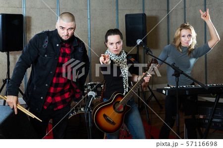 group of rock musicians posing with instruments 57116698
