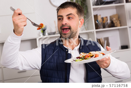 Portrait of young man eating vegetable salad 57116758