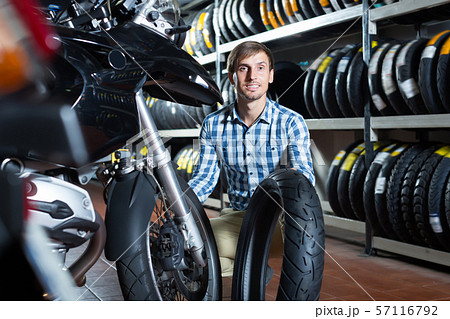 Glad man customer holding his motorcycle 57116792