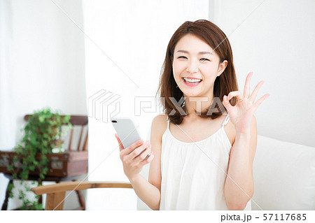 スマホを持つ笑顔の女性 57117685
