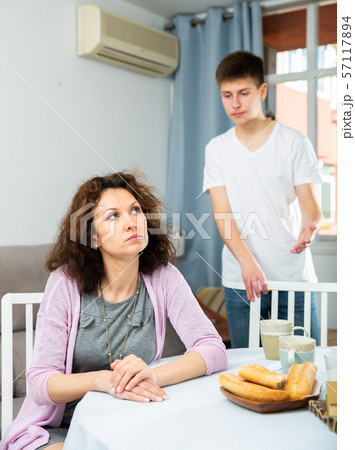 Upset woman after quarrel with teenage son 57117894