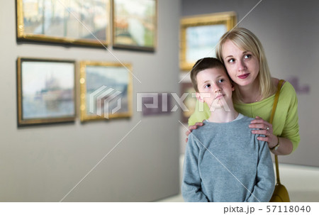 Mother and son looking at paintings in halls of museum 57118040