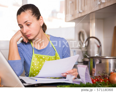 Tired young woman reading recipe in the kitchen 57118360