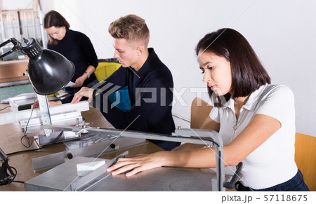 Female student using scroll saw in architectural modeling 57118675