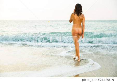 Nude girl standing on beach 57119019