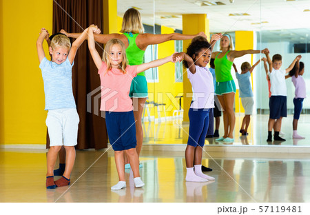 Group of tweens exercising folk dance, forming circle with femal Group of tweens exercising folk dance, forming circle with femal 57119481