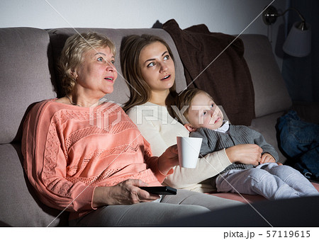 Two women and toddler are enjoying of watch film in evening Two women and toddler are enjoying of watch film in evening 57119615