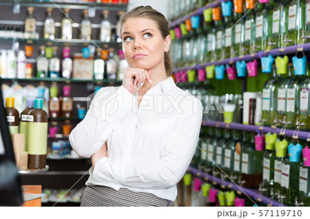 Girl thinking about buying new perfume in cosmetics shop 57119710