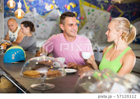 Climbers discussing over cup of coffee in sports bar at gym 57120112