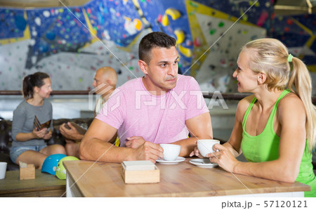 Climbers discussing over cup of coffee in sports bar at gym 57120121