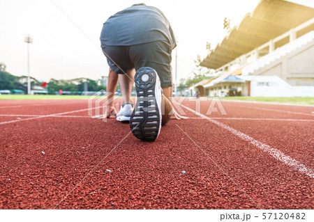 Running man rear view on race track with stadium 57120482