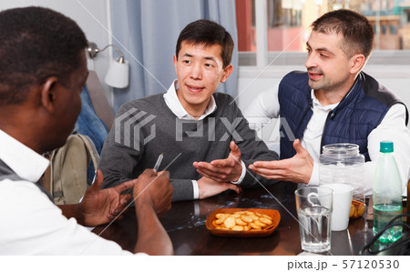 Smiling men are drinking beer and talking together Smiling men are drinking beer and talking together 57120530