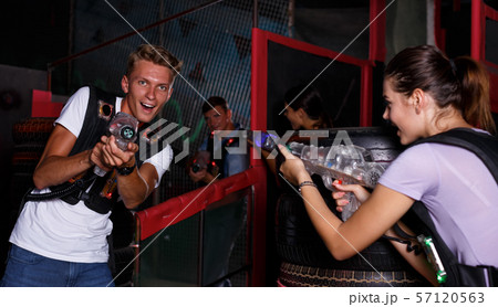 Positive guy holding laser guns and took aim during laser tag game Positive guy holding laser guns and took aim during laser tag game 57120563