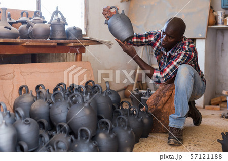 Craftsman examining handmade earthenware Craftsman examining handmade earthenware 57121188